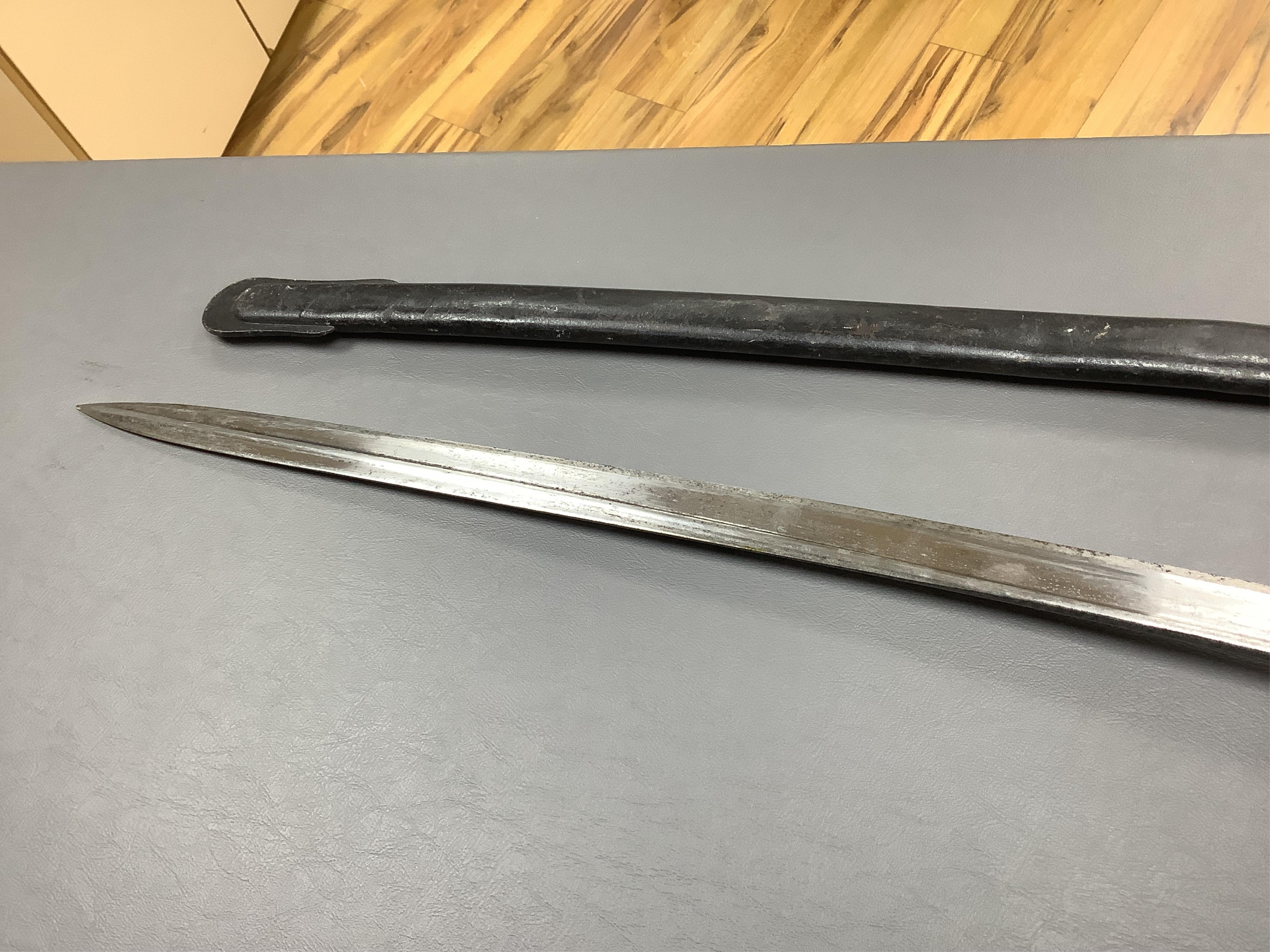 A First World War Turkish army officer’s sword, with pipe back blade, regulation iron guard pierced with crescent and moon, chequered horn grips, in its iron scabbard, together with an unidentified bayonet in its scabbar